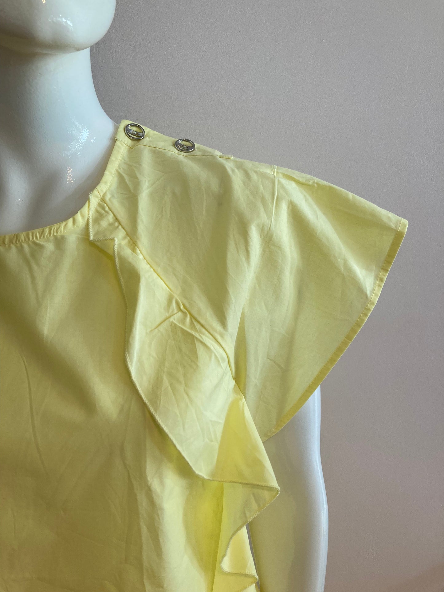 Yellow blouse with ruffle and three buttons on the shoulders