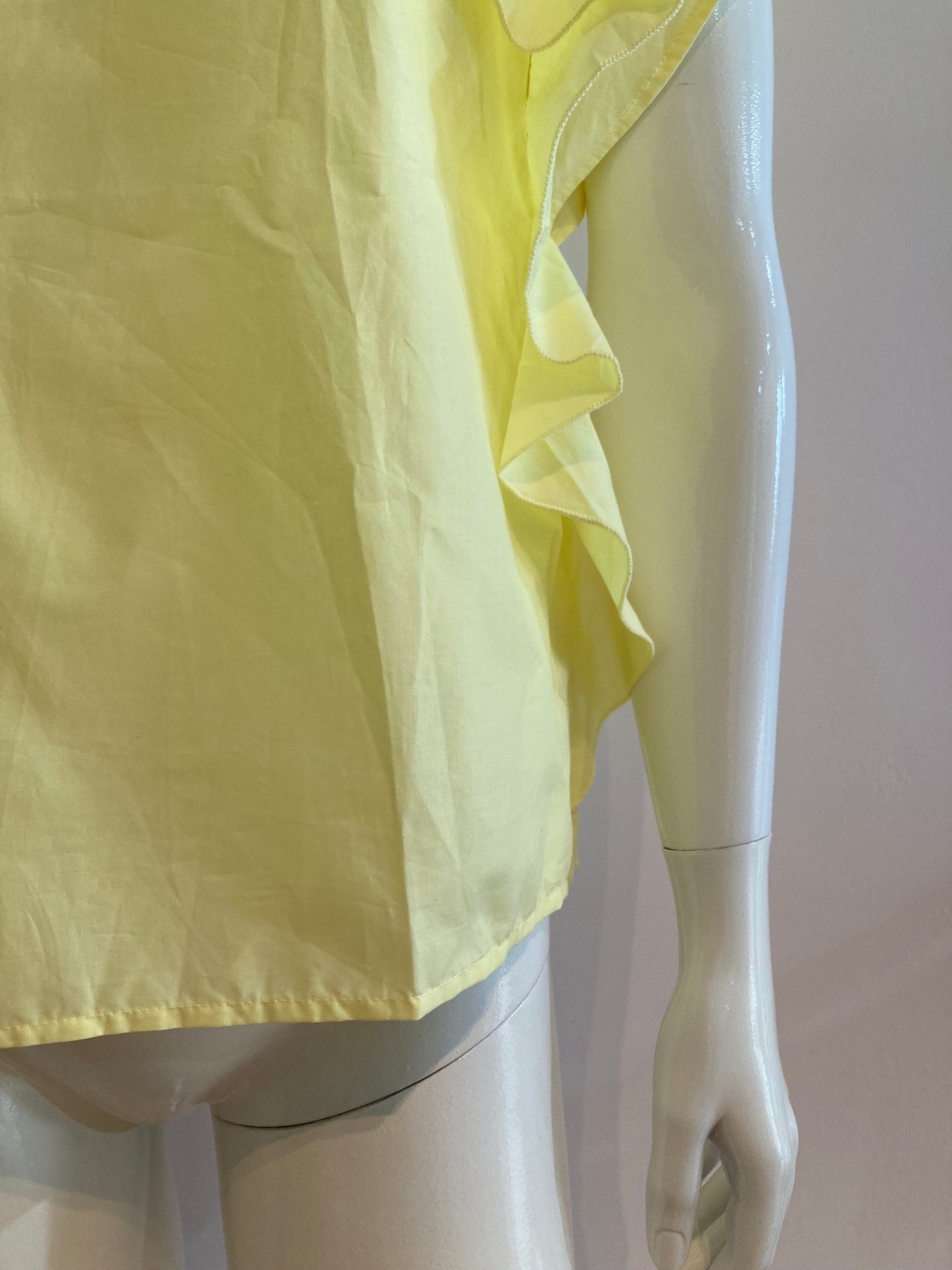 Yellow blouse with ruffle and three buttons on the shoulders