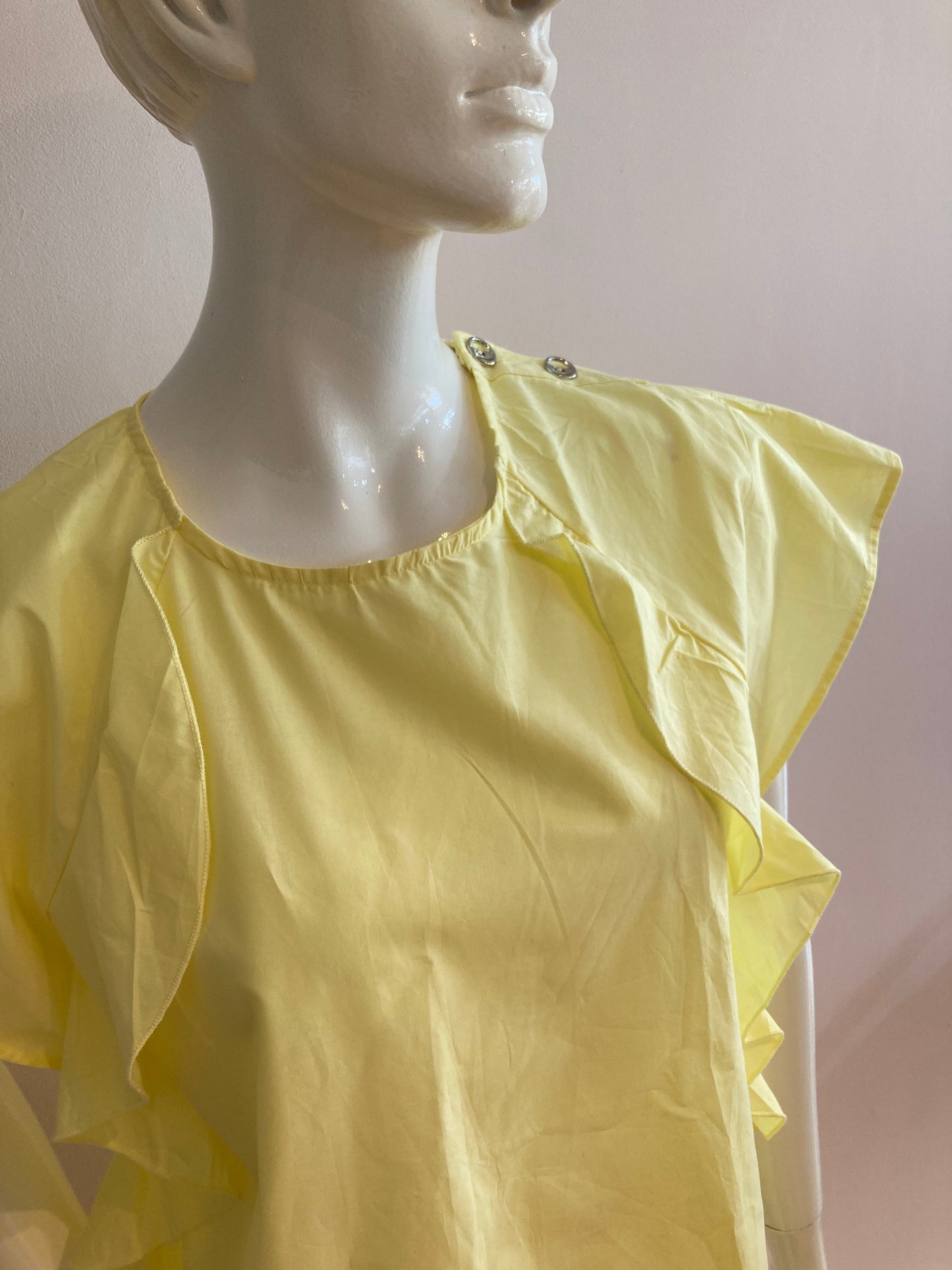 Yellow blouse with ruffle and three buttons on the shoulders