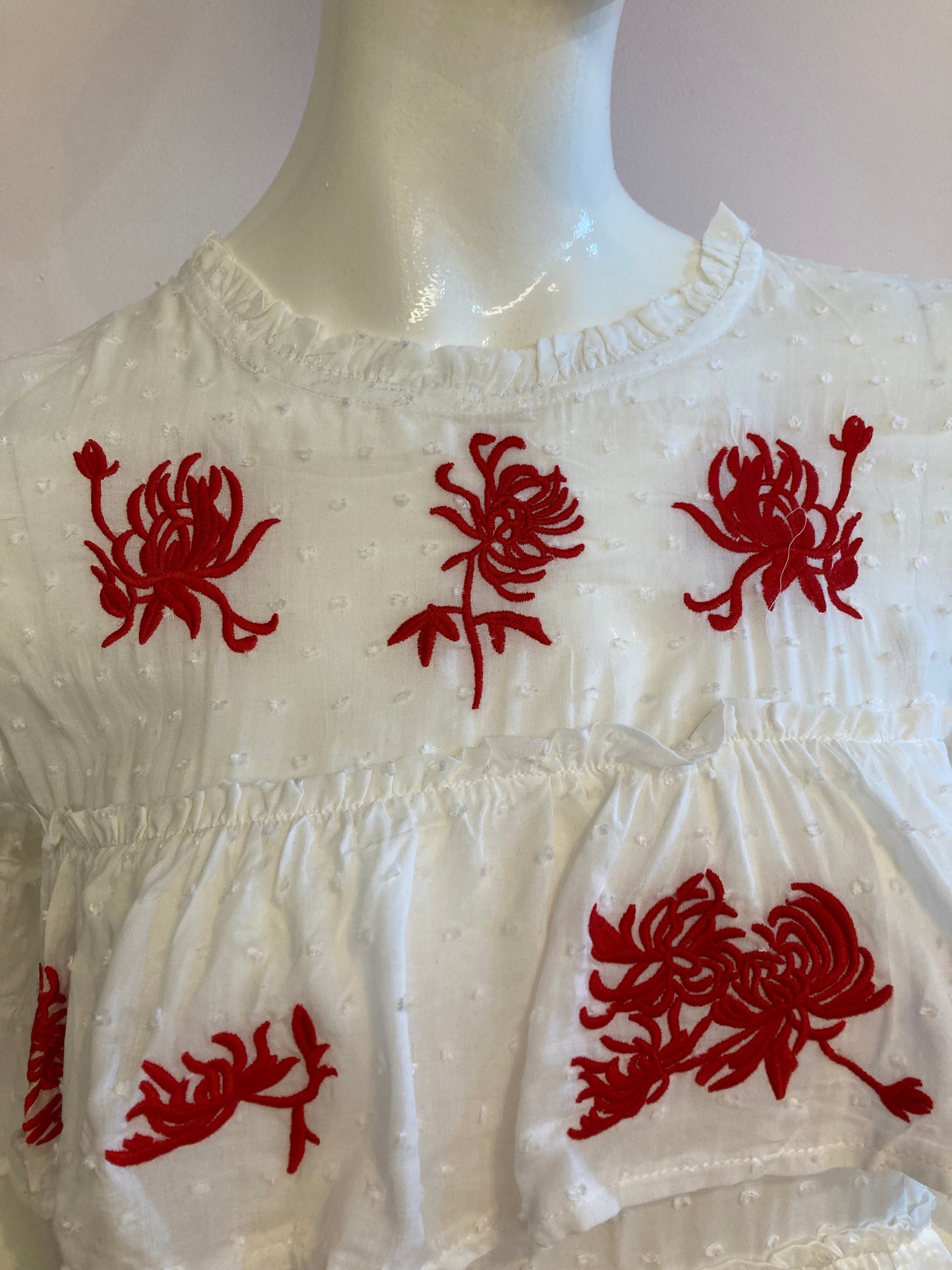 White top with ruffle and red embroidery